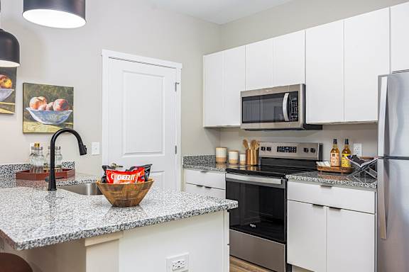 A kitchen with a granite countertop and a refrigerator.