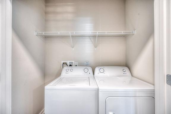A small laundry room with a washer and dryer.