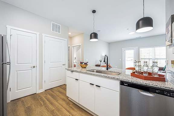 A kitchen with white cabinets and a stainless steel dishwasher.