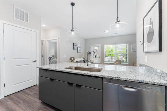A modern kitchen with a white door and a granite countertop.