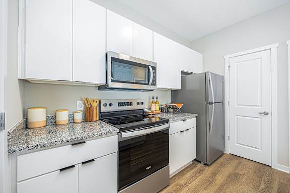 A kitchen with white cabinets and a microwave above the stove.