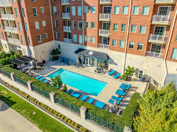 A large red brick building with a pool in front.