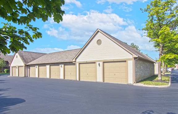 a row of garages in a parking lot with trees
