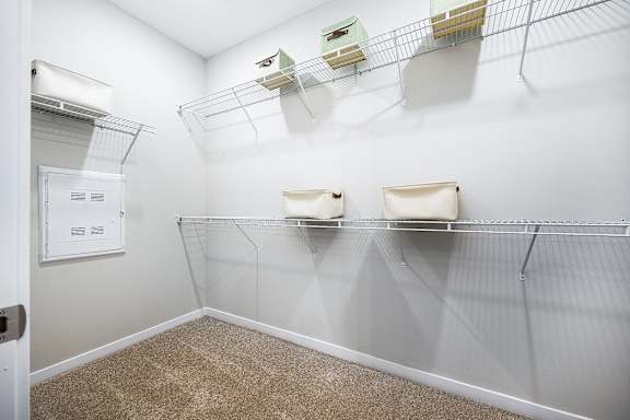 a spacious closet with shelves and a dryer in the corner of the room