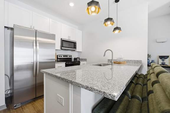 A kitchen with a granite countertop and stainless steel appliances.