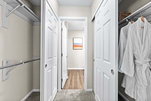 A hallway with white doors and a white robe hanging on the right door.