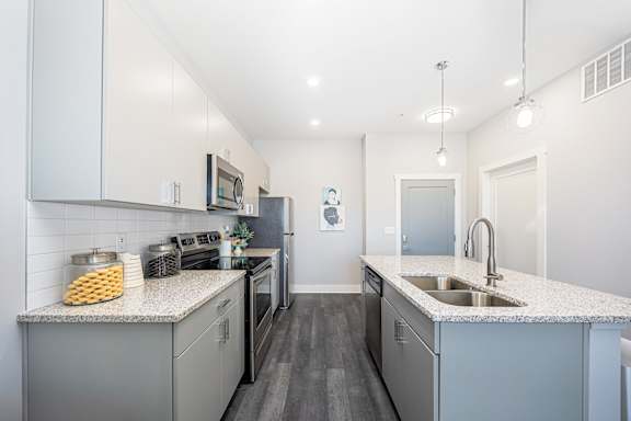 A modern kitchen with granite countertops and stainless steel appliances.