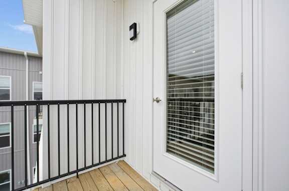 A balcony with a black railing and a door with a number 1 on it.