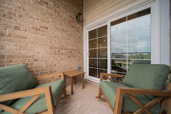 A room with a brick wall and a glass door.