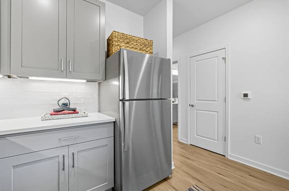 A kitchen with a refrigerator, cabinets, and a countertop.