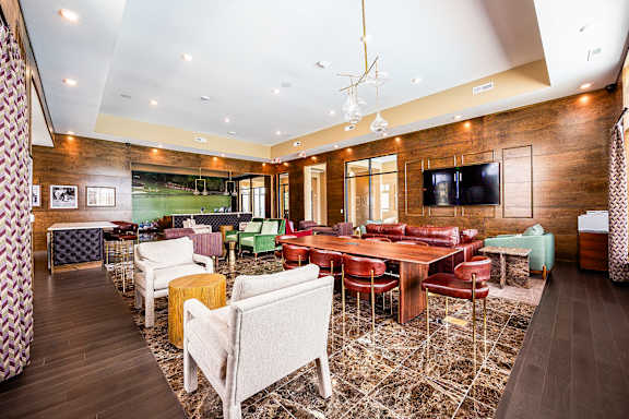A room with a long table surrounded by chairs.