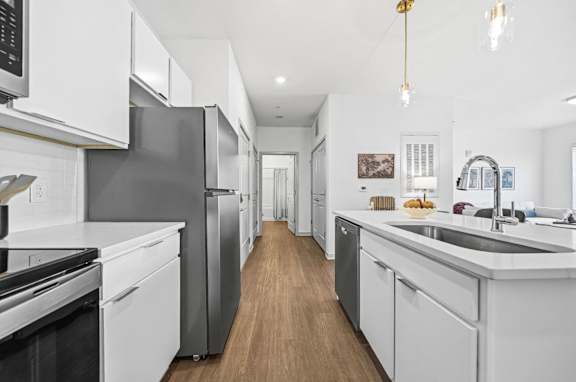 A modern kitchen with white cabinets and stainless steel appliances.