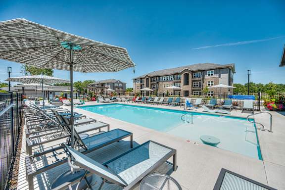 A sunny day at the pool with lounge chairs and umbrellas.
