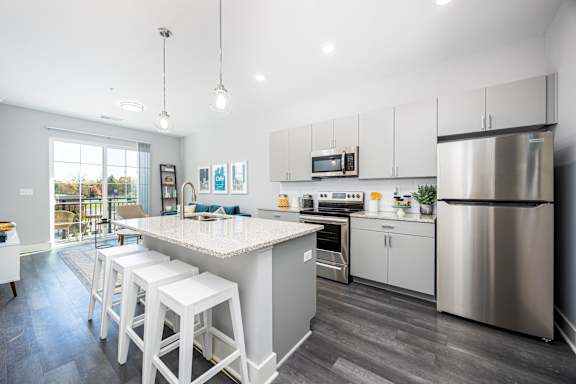 A modern kitchen with a large island and stainless steel appliances.