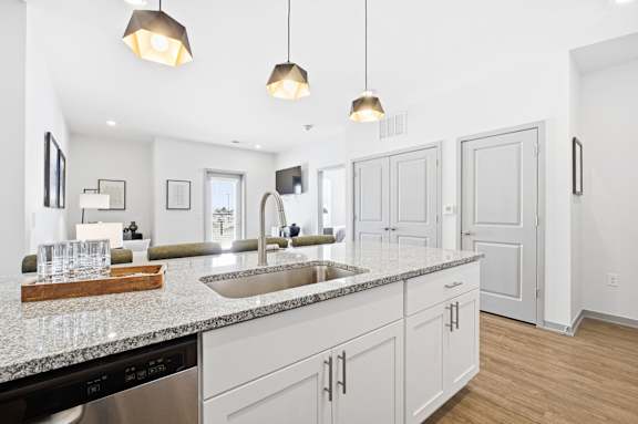 A modern kitchen with a marble countertop and stainless steel appliances.