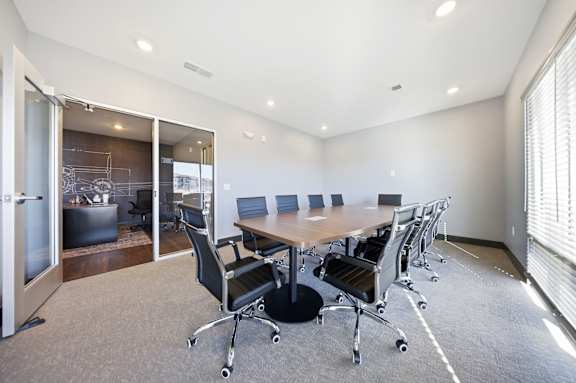 A conference room with a table and chairs.
