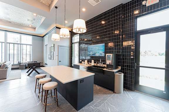 A modern kitchen with a bar area and a dining table.