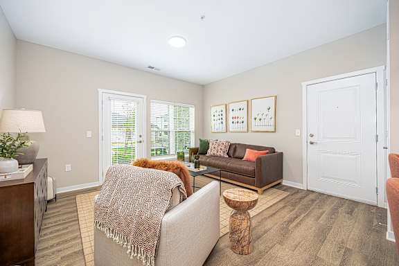 A living room with a couch, a chair, a table, and a lamp.