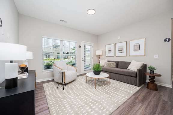 A living room with a grey couch, a white chair, and a coffee table.