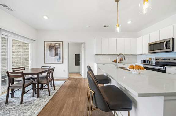 A kitchen with a dining table and chairs.