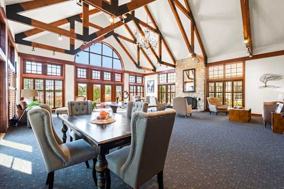 A large dining room with a long table and chairs.