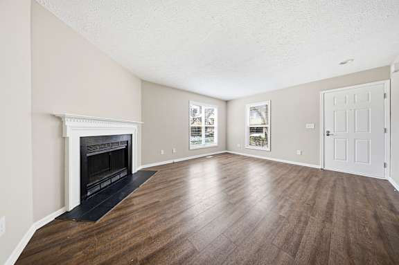 A room with a fireplace and wood flooring.