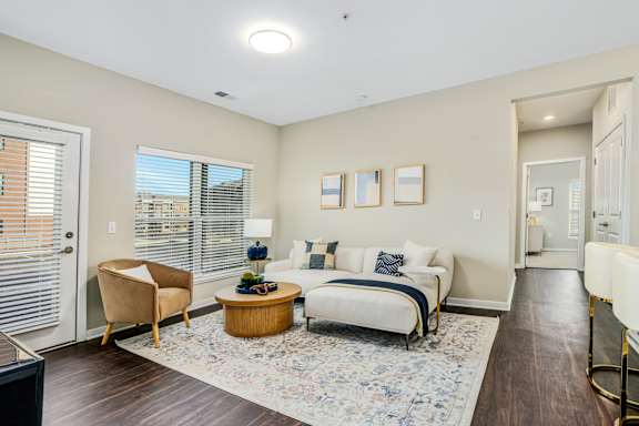 a living room with a couch and a chair and a door to a bedroom