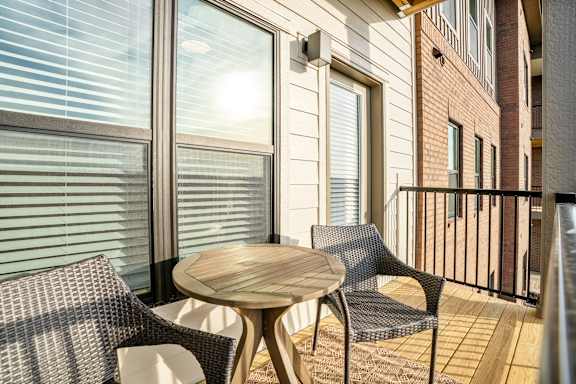 a patio with chairs and a table on a balcony
