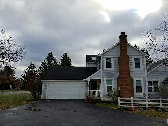 A house with a white fence and a brick chimney.
