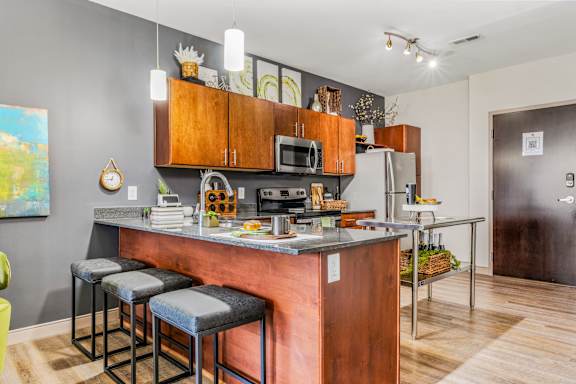 A kitchen with a bar stool and a painting on the wall.