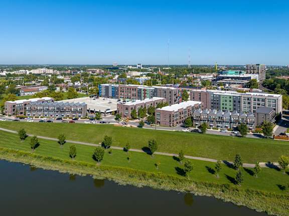 A large building complex sits on the edge of a body of water.