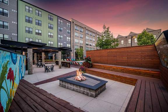 A fire pit sits in the middle of a wooden deck.