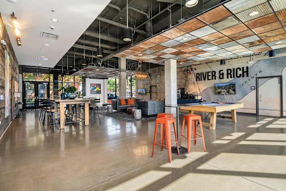 A modern interior with a bar area and a sign that reads "River & Rich".