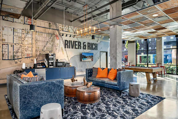A modern living room with a blue couch and a rug.