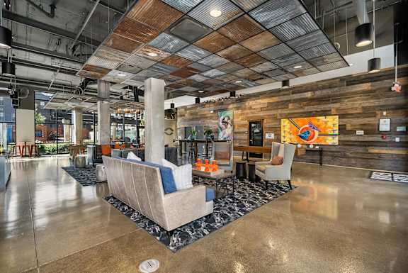 A modern office lobby with a wooden wall and a large chair in the center.