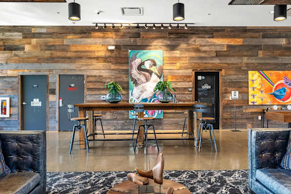 A room with a wooden wall and a painting of a woman.