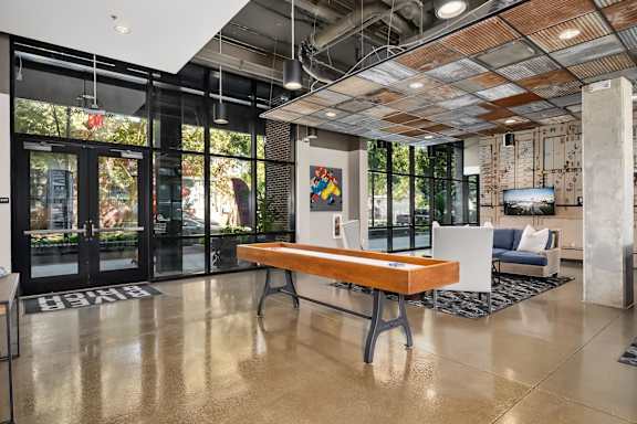 A modern office lobby with a wooden bench and a white reception desk.