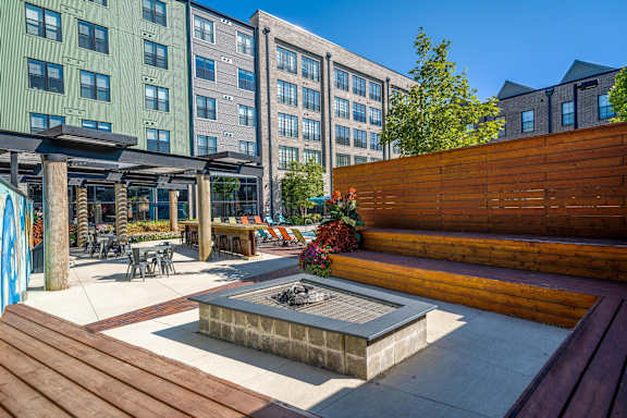 A modern outdoor seating area with a fire pit in the center.