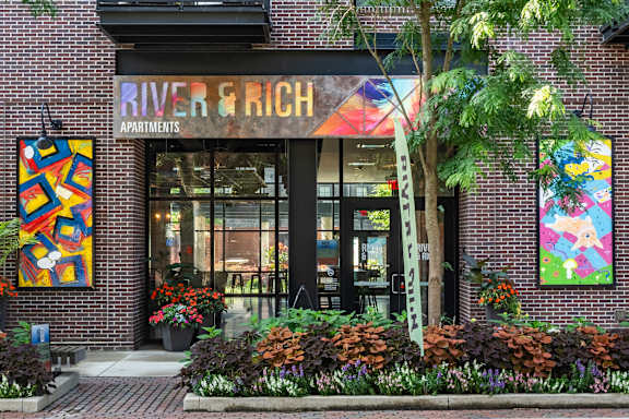 A building with a sign that says River & Rich Apartments.