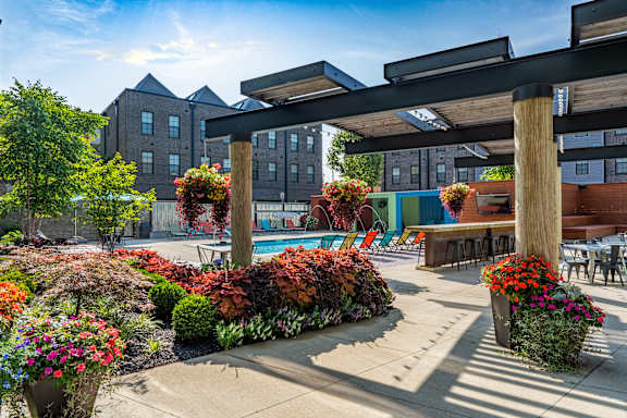 A patio area with a pool and a building in the background.
