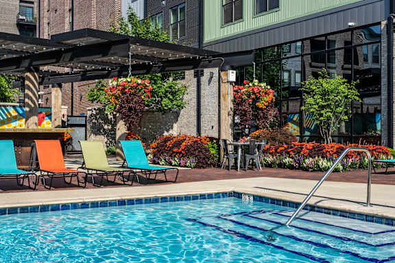 A pool with a ladder and a table with chairs.