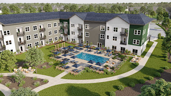 A large apartment complex with a pool in the middle of the courtyard.