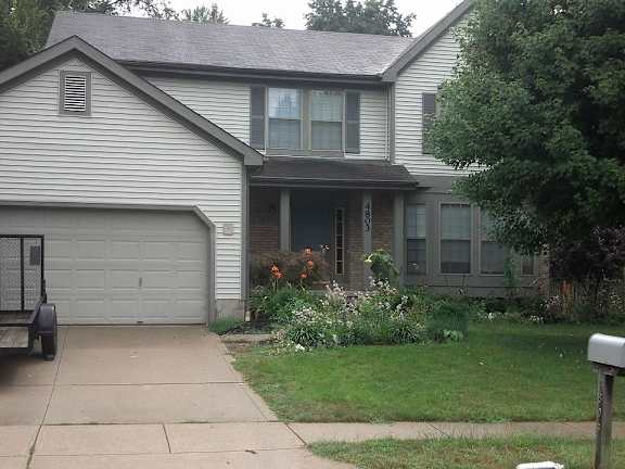 A house with a grey garage door and a mailbox on the right side.