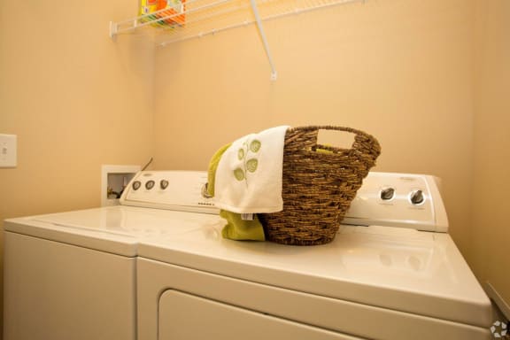 Laundry room with full size washer and dryer and shelf for storage at Ashley Auburn Pointe in Atlanta, GA