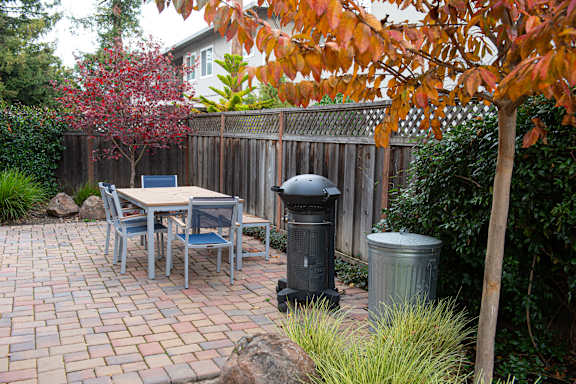 A table and chairs are set up on a brick patio.