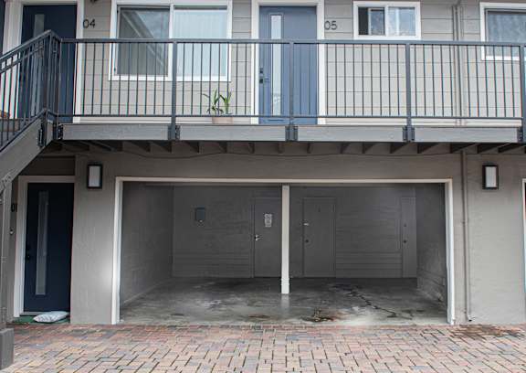 A building with a balcony and a garage.
