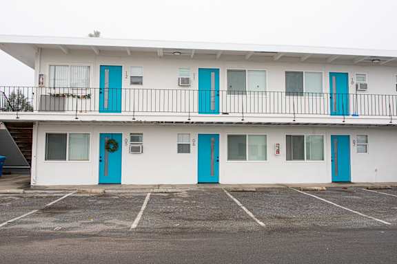 A white building with blue doors and windows.