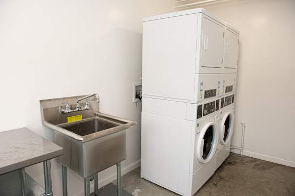 A white washing machine and sink in a room.