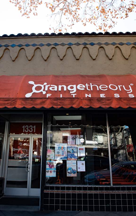 A fitness storefront with a red awning and white sign.