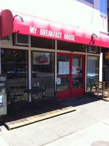 a restaurant with a red awning and tables and chairs